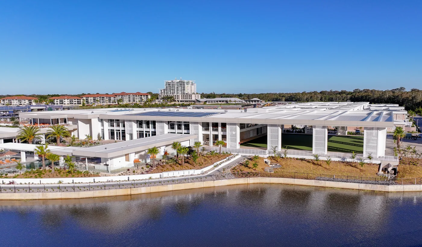 The country club seen across the lake, pergola and screening visible along the waterfront elevation