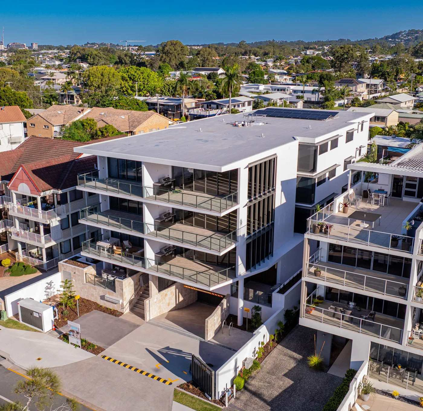 The finished PRANA building at Maroochydore, with K&F glass balustrades and black window hoods across its balconies