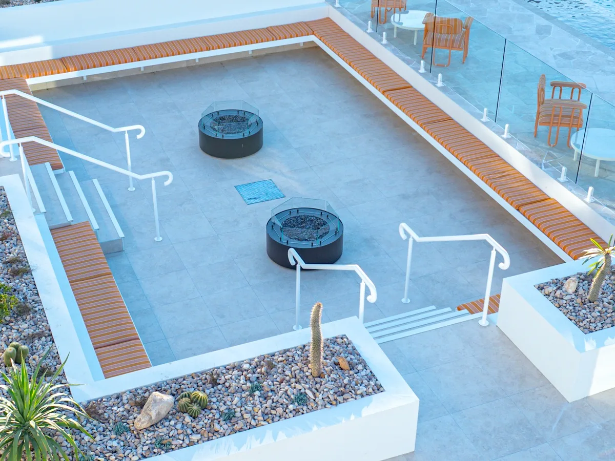 White steel handrails to the steps of a sunken poolside terrace